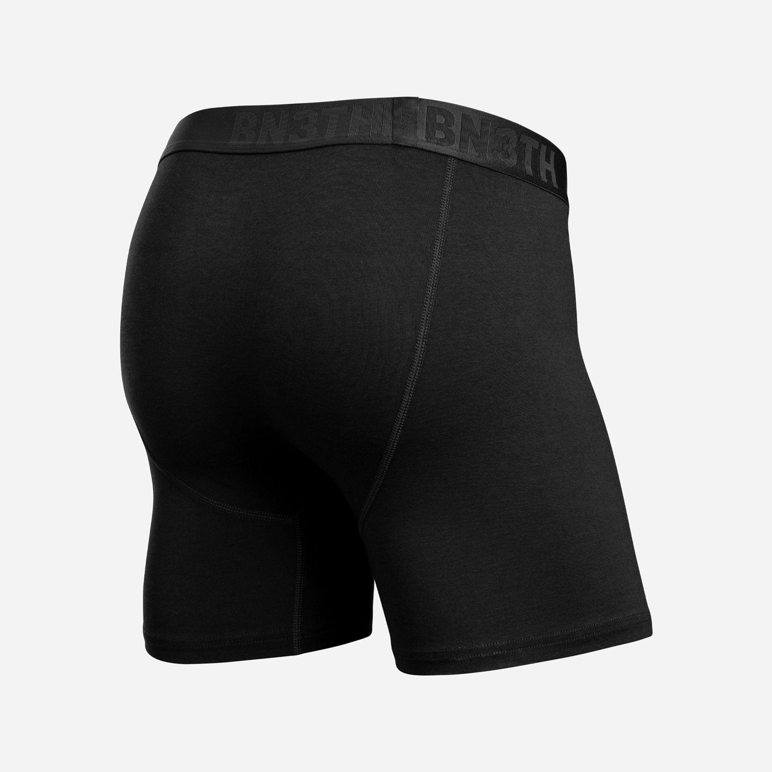 Black boxer briefs shown from a rear three-quarter view, featuring a wide black elastic waistband with the brand name 'BN3TH' partially visible in tonal lettering. Essentials Boxer Brief: Black